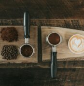 coffee beans beside coffee powder on brown wooden board