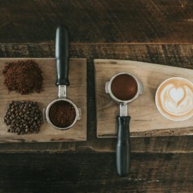 coffee beans beside coffee powder on brown wooden board